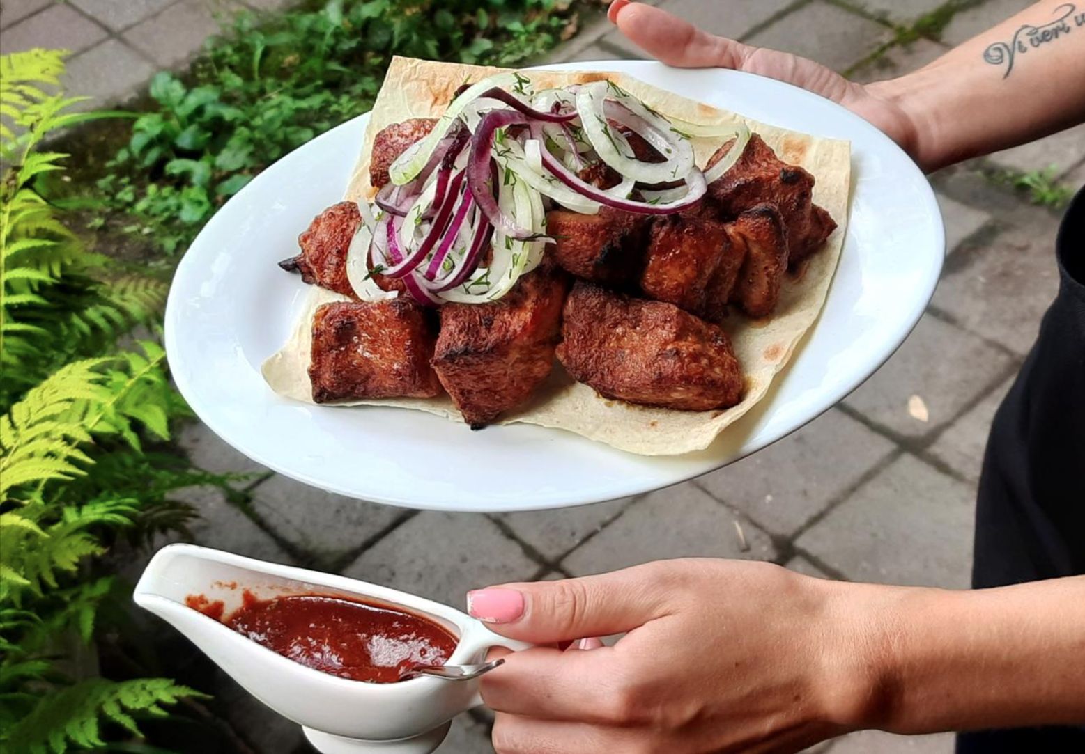 Блюдо с мясом на гриле, свежими овощами и зеленью